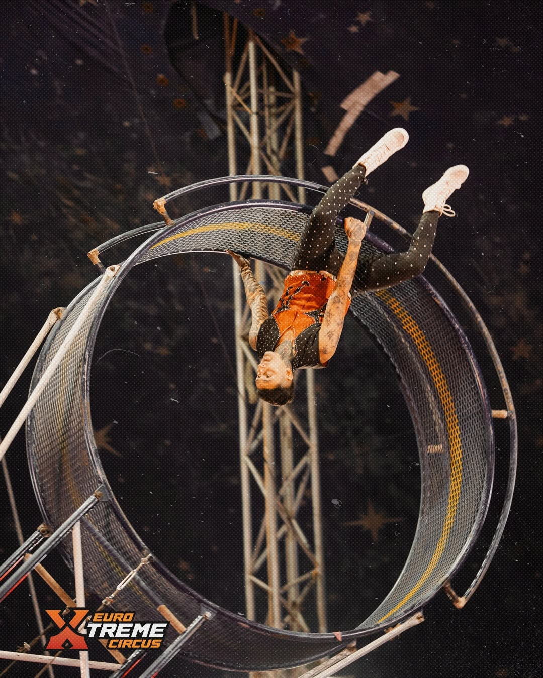 Circus performer balancing high above the stage on a wheel act